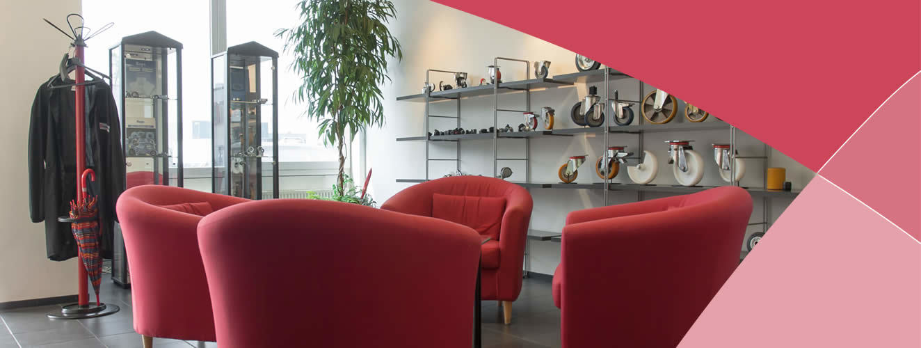 Showroom met rode stoelen en vitrines vol transportwielen en lagers